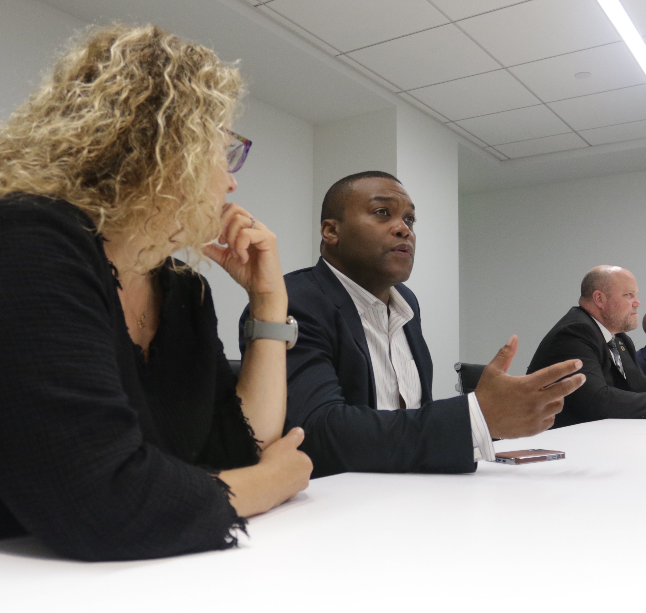 Staff at a conference table. One person is pointing.